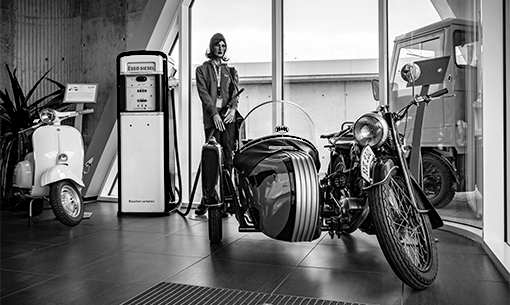 Historisches Motorrad mit Seitenwagen im Ausstellungsraum. Daneben eine alte ESSO-Zapfsäule.