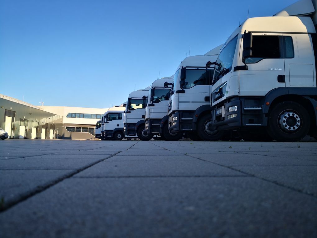 LKW-Flotte auf dem Betriebshof von euro.COURIER, vom Boden aus fotografiert.