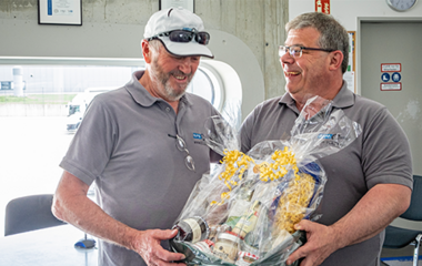 Ein Mitarbeiter von euro.COURIER feiert sein Betriebsjubiläum mit einem großen Präsentkorb.