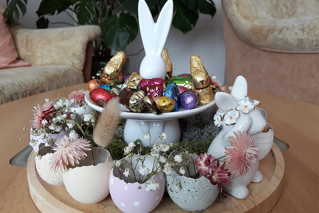 Tolles Porzellangesteck mit Schoklade, Blumen und Eierschalen ziert den Tisch im Overnight-Büro.