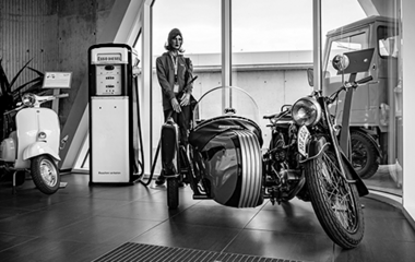 Historisches Motorrad mit Seitenwagen im Ausstellungsraum. Daneben eine alte ESSO-Zapfsäule.