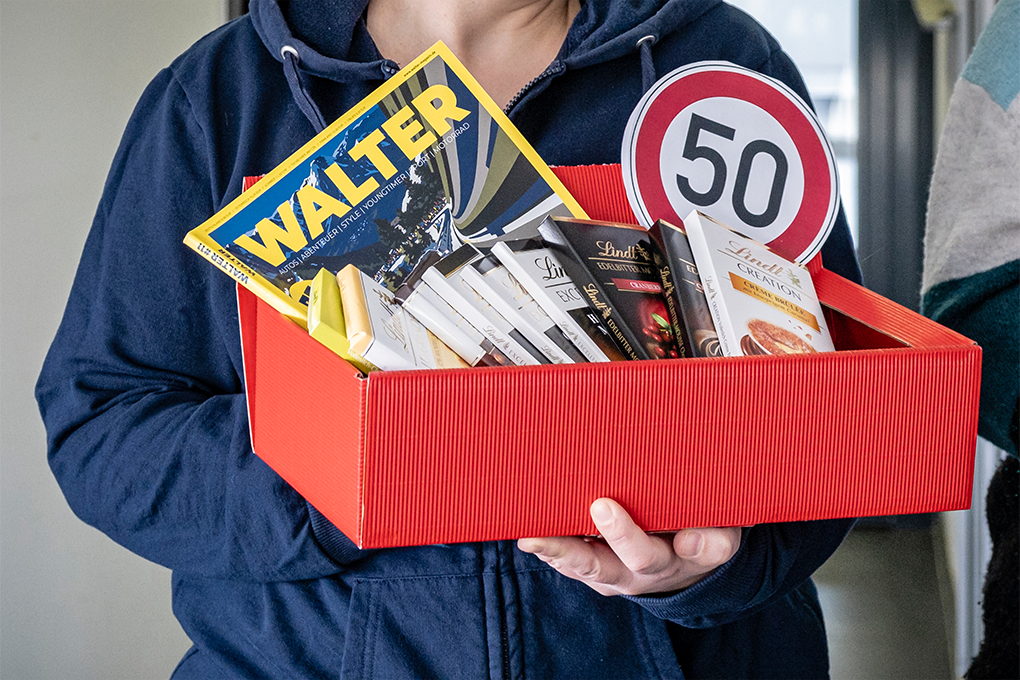 Präsentkorb mit einem 50 kmh-Schild, Schokolade und einer Zeitschrift als Geschenk für den Logistikspezialisten.