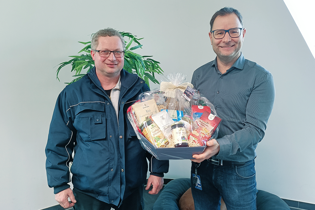 Mitarbeiter bekommt vom Geschäftsführer einen Präsentkorb zum Firmenjubiläum. Danke für die gute und vertrauensvolle Zusammenarbeit.