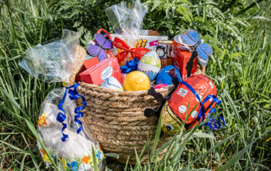 Osterkorb im Gras mit viel Schokolade.